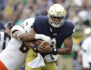 Notre Dame quarterback DeShone Kizer (14) is tackled by Miami 's RJ McIntosh during the first half of an NCAA college football game Saturday, Oct. 29, 2016, in South Bend, Ind. (AP Photo/Darron Cummings)